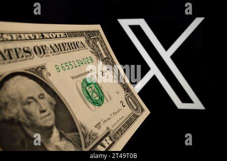 Banconota da 1 dollaro davanti al logo della piattaforma di social media Blurred X (ex Twitter). Concetto di un piano di abbonamento a pagamento. Stafford, Regno Unito, Octob Foto Stock