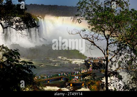 I turisti camminano sulle piattaforme delle cascate dell'Iguazú sul lato brasiliano Foto Stock