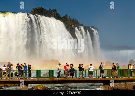 Parco nazionale dell'Iguazú, Brasile - 26 luglio 2022: I turisti camminano sulle piattaforme delle cascate dell'Iguazú di fronte alla cascata di Santa Maria Foto Stock