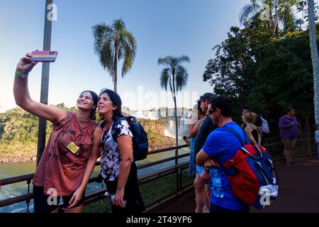 Parco nazionale dell'Iguazú, Argentina - 25 luglio 2022: I turisti scattano un selfie con le cascate dell'Iguazú sullo sfondo Foto Stock