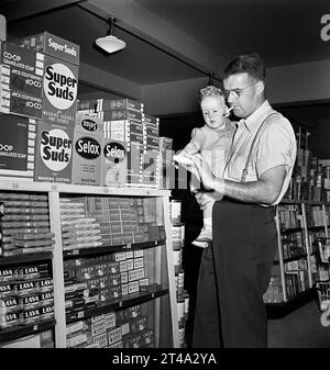 Padre con figlio neonato che fa shopping in un negozio di alimentari cooperativo, Greenbelt, Maryland, USA, Marjory Collins, U.S. Office of War Information, giugno 1942 Foto Stock