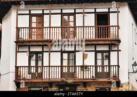 Pittoresca architettura a Santillana del Mar, con una facciata bianca e uno splendido balcone in legno Foto Stock