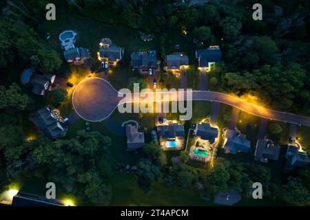 Vista dall'alto delle case residenziali nella zona giorno di Rochester, New York di notte. Case da sogno americane illuminate come esempio di sviluppo immobiliare Foto Stock