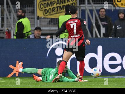 29 ottobre 2023, Assia, Francoforte sul meno: Calcio: Bundesliga, Eintracht Frankfurt - Borussia Dortmund, Matchday 9, presso Deutsche Bank Park. L'Omar Marmoush di Francoforte (r) viene attaccato dal portiere di Dortmund Alexander Meyer. Foto: Arne Dedert/dpa - NOTA IMPORTANTE: In conformità ai requisiti della DFL Deutsche Fußball Liga e del DFB Deutscher Fußball-Bund, è vietato utilizzare o far utilizzare fotografie scattate nello stadio e/o della partita sotto forma di immagini di sequenza e/o serie di foto simili a video. Foto Stock