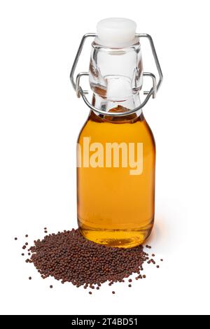 Bottiglia con olio di senape marrone e semi di senape nera nella parte anteriore isolati su sfondo bianco da vicino Foto Stock