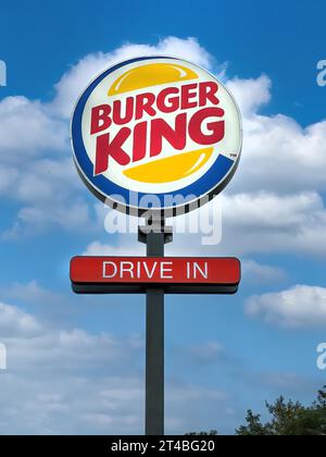 Logo e pubblicità per la catena di fast food Burger King con le parole Drive in Below, cielo blu con nuvole bianche sullo sfondo, Internazionale Foto Stock