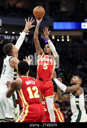 Milwaukee, USA. 29 ottobre 2023. Dejounte Murray degli Atlanta Hawks (top, R) tira la palla durante la partita della stagione regolare NBA 2023-2024 tra Atlanta Hawks e Milwaukee Bucks a Milwaukee, Wisconsin, Stati Uniti, il 29 ottobre 2023. Crediti: Joel Lerner/Xinhua/Alamy Live News Foto Stock