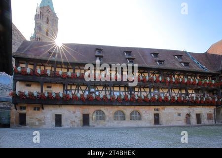 Cortile interno dell'alte Hofhaltung costruito nel XV secolo con decorazione floreale nel retroilluminato, torre della chiesa, costruzione in legno, metà in legno Foto Stock