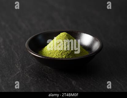 Tè verde Matcha su sfondo nero. Polvere Matcha. Foto Stock
