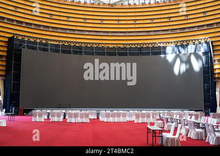 Tavolo da pranzo e grande schermo nella grande sala per banchetti al coperto Foto Stock