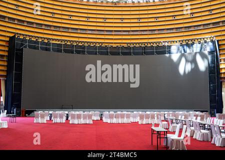 Tavolo da pranzo e grande schermo nella grande sala per banchetti al coperto Foto Stock