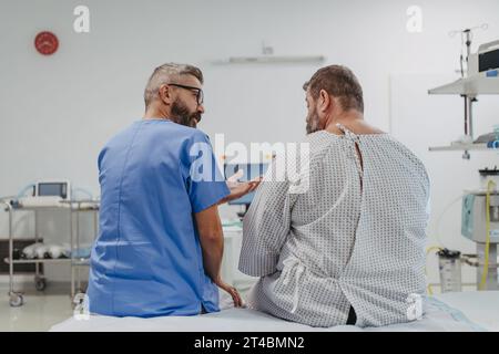 Medico di supporto lenire un paziente in sovrappeso preoccupato, discutendo il risultato del test in pronto soccorso. Malattie e malattie nella salute degli uomini di mezza età Foto Stock