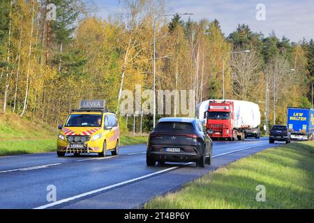 Il rimorchio a pianale Volvo FH rosso M Nikkanen Ky trasporta carichi larghi lungo l'autostrada 25. Il traffico che sopraggiunge cede. Raasepori, Finlandia. 13 ottobre 2023. Foto Stock