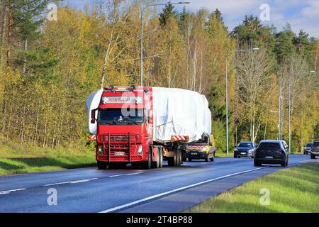 Il rimorchio a pianale Volvo FH rosso M Nikkanen Ky trasporta carichi larghi lungo l'autostrada 25. Il traffico che sopraggiunge cede. Raasepori, Finlandia. 13 ottobre 2023. Foto Stock