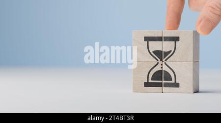 Pianificazione e gestione dei tempi efficaci. Pianificazione e gestione delle scadenze. icona a forma di clessidra su blocchi cubici di legno. copia spazio. Foto Stock
