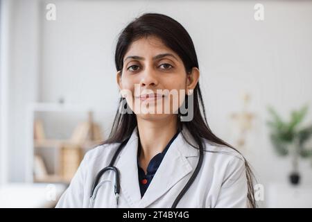 Ritratto di una medico con stetoscopio in posa al chiuso Foto Stock