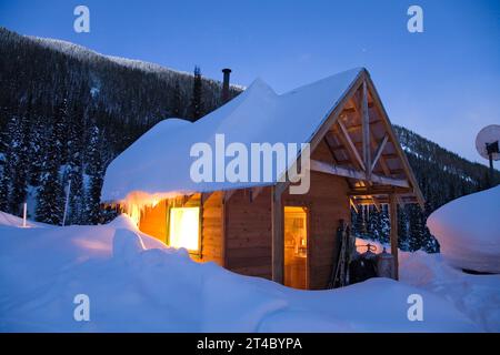 Cabina al crepuscolo d'inverno, Valhalla Mountain Touring Lodge, British Columbia, Canada Foto Stock