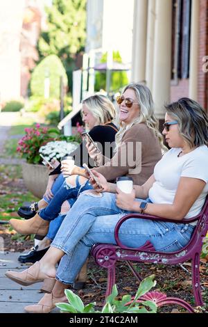 Immagine verticale di donne sui telefoni e che bevono caffè Foto Stock