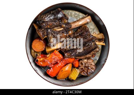 Stecche di agnello brasate fatte in casa con salsa ed erbe in un vassoio di acciaio Isolato su sfondo bianco Foto Stock