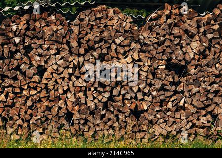 Grande pila di legna da ardere tagliata sui terreni agricoli essiccazione in estate, concentrazione selettiva Foto Stock