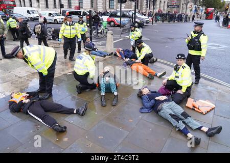 Just Stop Oil attivisti manifestano a Parliament Square, Westminster, nel centro di Londra, per chiedere al governo di fermare immediatamente tutti i nuovi progetti di petrolio, gas e carbone nel Regno Unito. Data immagine: Lunedì 30 ottobre 2023. Foto Stock