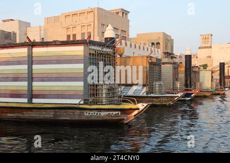 29 ottobre 2023, Dubai, Emirati Arabi Uniti. Una mattina presto da Dubai Abra con edificio tradizionale e barche. È una modalità di viaggio comune per l'uomo e per i turisti. Foto Stock