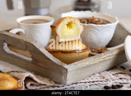 Pasticciotto leccese ripieno di crema pasticcera all'uovo, dolce tipico di Lecce, Italia. Pezzi di pasticiotto su vassoio di legno, colazione pugliese Foto Stock