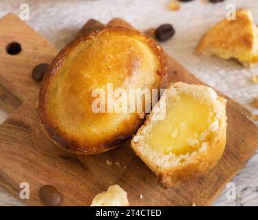 Pasticciotto leccese ripieno di crema pasticcera all'uovo, dolce tipico di Lecce, Italia. Pezzi di pasticiotto su tavola di legno, colazione pugliese Foto Stock