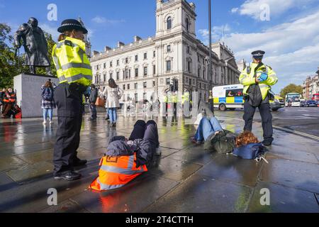 Londra, Regno Unito. 30 ottobre 2023. Just Stop Oil attivisti per il clima vengono arrestati e ammanettati dalla polizia dopo aver bloccato il traffico con una “lenta marcia” fuori dal parlamento di Westminster . Just Stop Oil ha promesso di portare avanti la loro campagna di disgregazione mentre il governo concede nuove licenze per i combustibili fossili. Credit amer ghazzal/Alamy Live News Foto Stock