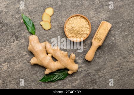 Polvere di zenzero finemente asciutta in recipiente con foglie verdi isolate su sfondo colorato. Vista dall'alto posa piatta. Foto Stock