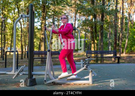 Atletica donna di mezza età che fa esercizi nel parco. Foto Stock