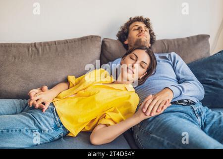 Ritratto della giovane coppia felice a casa. Si rilassano sul divano. Foto Stock
