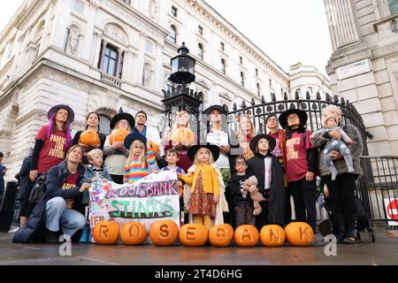 I genitori del gruppo per la campagna sul clima i genitori per il futuro e i loro figli si preparano a consegnare una petizione "Stop Rosebank oil Field" al 10 di Downing Street a Londra. Data immagine: Lunedì 30 ottobre 2023. Foto Stock