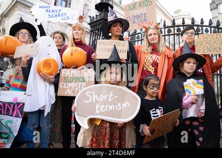 I genitori del gruppo per la campagna sul clima i genitori per il futuro e i loro figli si preparano a consegnare una petizione "Stop Rosebank oil Field" al 10 di Downing Street a Londra. Data immagine: Lunedì 30 ottobre 2023. Foto Stock