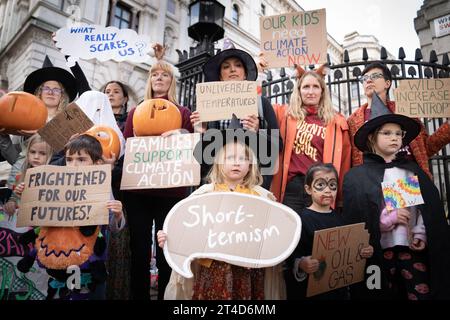 I genitori del gruppo per la campagna sul clima i genitori per il futuro e i loro figli si preparano a consegnare una petizione "Stop Rosebank oil Field" al 10 di Downing Street a Londra. Data immagine: Lunedì 30 ottobre 2023. Foto Stock