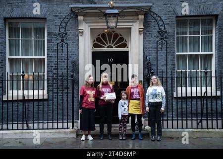 I genitori del gruppo per la campagna sul clima i genitori per il futuro e i loro figli si preparano a consegnare una petizione "Stop Rosebank oil Field" al 10 di Downing Street a Londra. Data immagine: Lunedì 30 ottobre 2023. Foto Stock