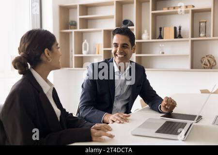 Un manager e un cliente allegri che discutono di una collaborazione di successo al laptop Foto Stock