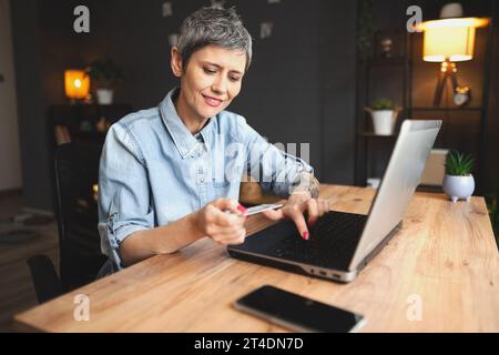 Donna matura che legge il piano per la costruzione di mobili Foto Stock