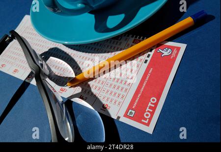 biglietto del lotto britannico e penna su sfondo blu Foto Stock