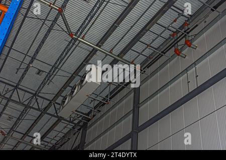 Un evaporatore in alto vicino al soffitto nel congelatore di un magazzino di stoccaggio a freddo di CO2 (refrigerazione industriale) in costruzione. Foto Stock