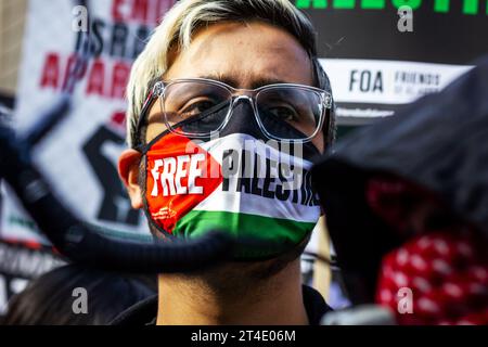 Un uomo che indossa la maschera per la Palestina libera durante una protesta di solidarietà con i palestinesi a Gaza, nel centro di Londra. Foto Stock