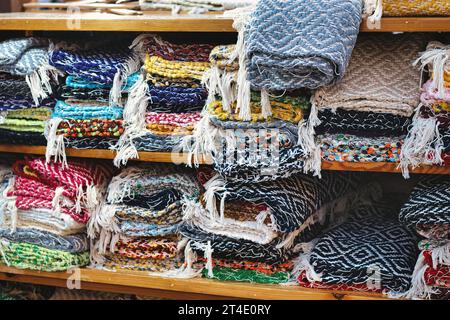 Una collezione di tappeti di straccio fatti a mano con un telaio tradizionale in un mercato di strada - niente gente Foto Stock