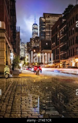 World Trade Center NYC - strada acciottolata con vista sul One World Trade Center comunemente conosciuto come la Freedom Tower dopo una pesante doccia serale. Foto Stock