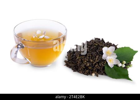 Foglie di tè essiccate, vivaci fiori di gelsomino bianco con foglia verde e tazza di tè di vetro isolata su sfondo bianco Foto Stock