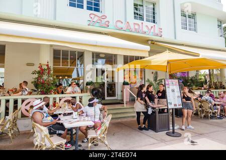 Miami Beach Florida, esterno, hotel con ingresso frontale, Ocean Drive, cartello Carlyle Cafe, uomo uomo uomo, donna donna donna donna donna donna, adulti residenti Foto Stock