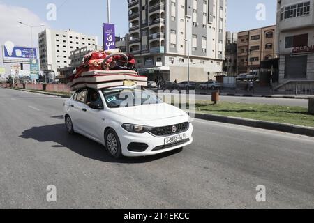 I palestinesi guidano un'auto carica di oggetti personali mentre fumano in sottofondo mentre fuggono dal campo profughi di Nuseirat i palestinesi guidano un'auto carica di oggetti personali mentre fumano sullo sfondo mentre fuggono dal campo profughi di Nuseirat, nella Striscia di Gaza centrale, il 30 ottobre 2023, tra le continue battaglie tra Israele e il gruppo palestinese Hamas. Foto di Naaman Omar apaimages Nuseirat Striscia di Gaza territorio palestinese 301023 Nuseirat NAA 004 Copyright: XapaimagesxNaamanxOmarxxxapaimagesx credito: Imago/Alamy Live News Foto Stock