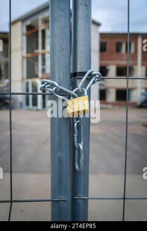 primo piano di un lucchetto in ottone con catena su una recinzione Foto Stock