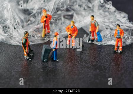 persone in miniatura di raccolta rifiuti rimozione rifiuti di plastica, temi ambientali Foto Stock