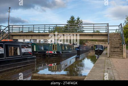 Strette barche ormeggiate nel bacino di Trevor viste sotto una passerella sul canale Union dello Shropshire nell'ottobre 2023. Foto Stock