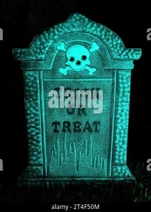 Lapide verde di Halloween illuminata con teschio e trucco o cortile decorativo di notte Foto Stock
